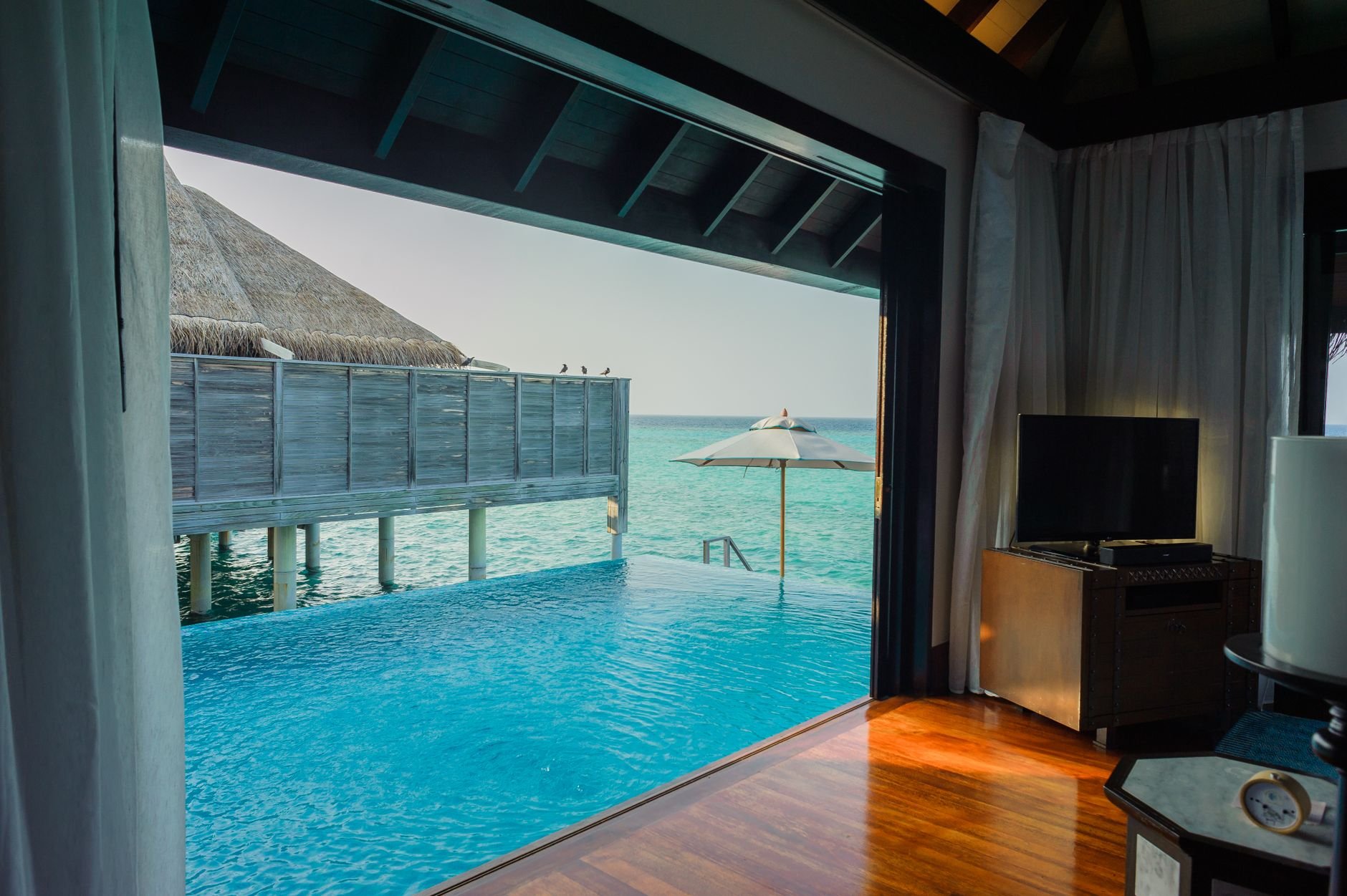 Elegant overwater villa in Maldives with infinity pool and ocean view for a serene getaway.
