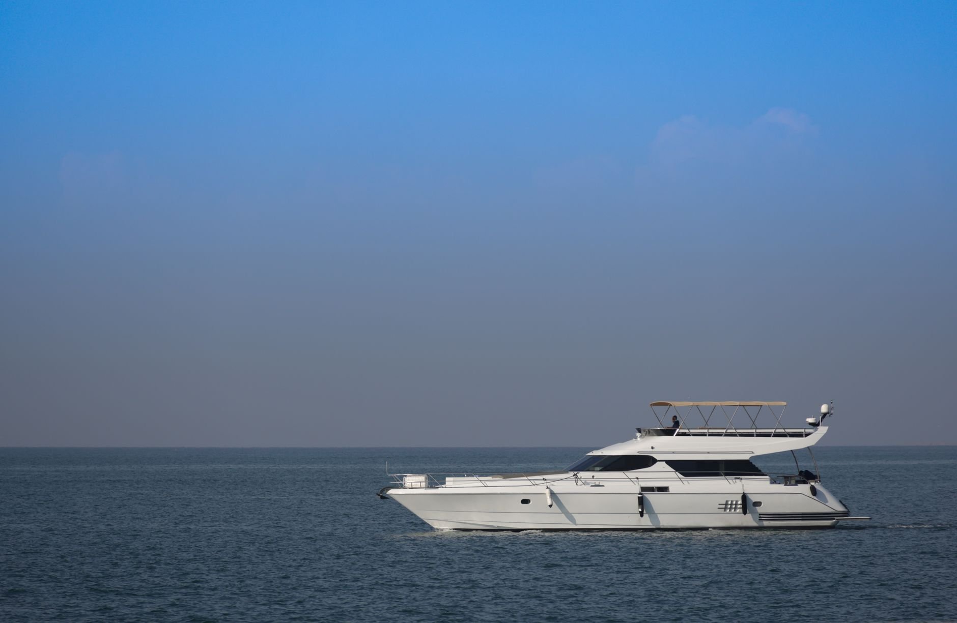 Elegant yacht sailing on serene ocean under a clear blue sky; perfect nautical escape.